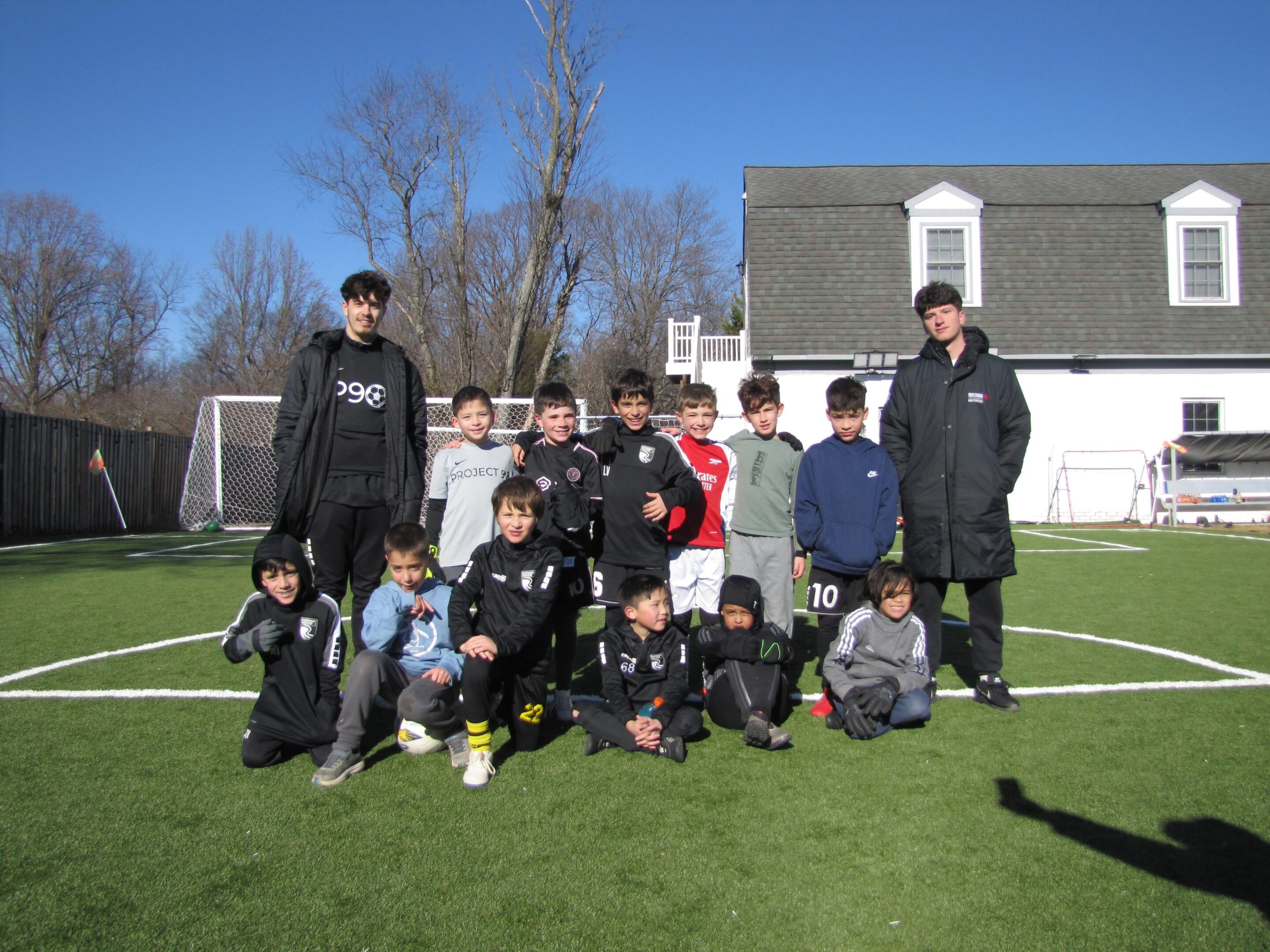 A group of young boys standing on top of a soccer field.
