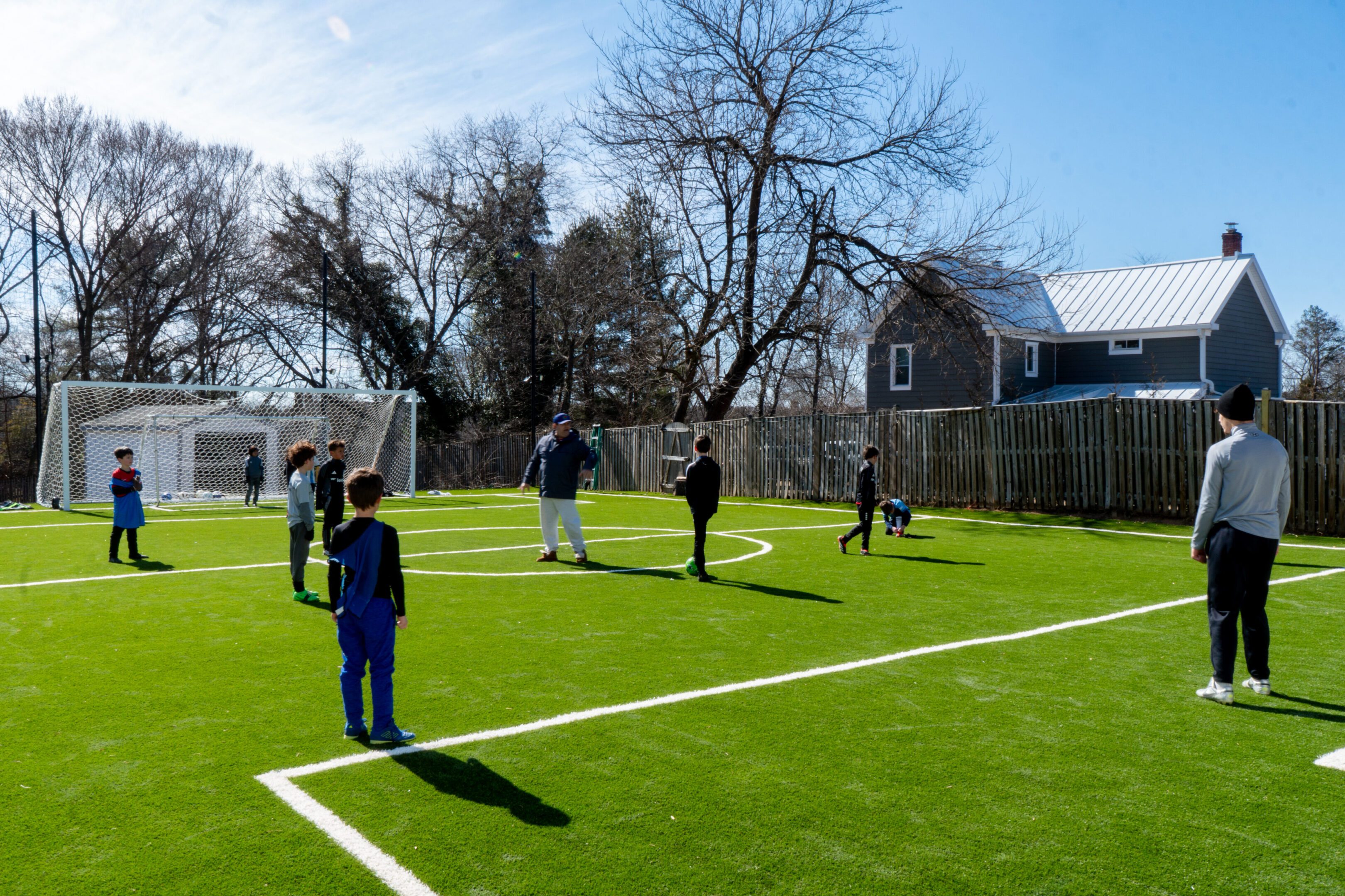 website pic6 A group of people standing on top of a soccer field.